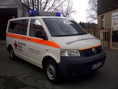 Foto: Krankenwagen von vorn vor einem Rapsfeld.